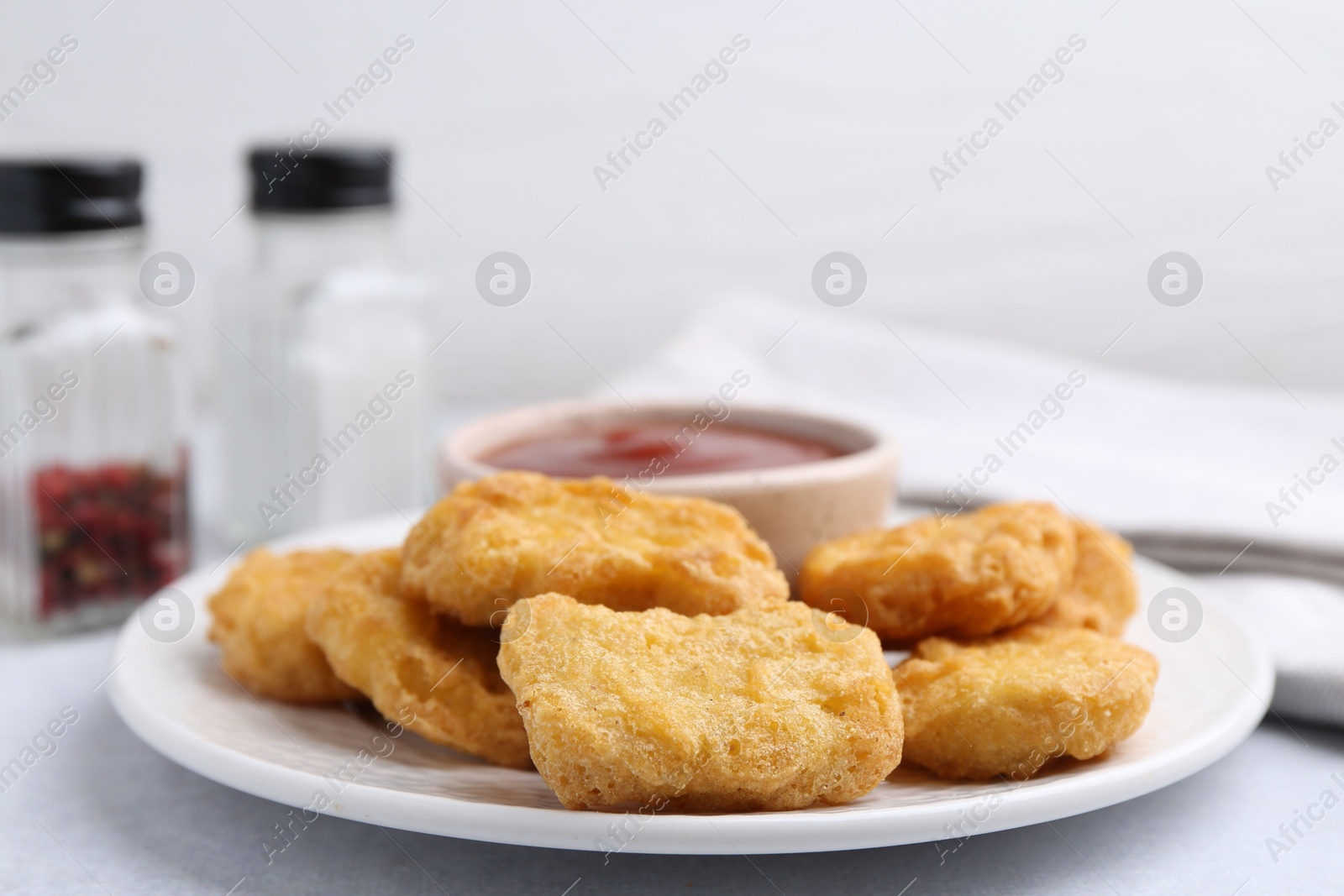 Tasty chicken nuggets with sauce on light table, closeup Photo of Tasty chicken nuggets with sauce on light table, closeup