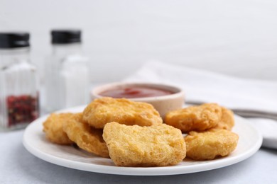Photo of Tasty chicken nuggets with sauce on light table, closeup