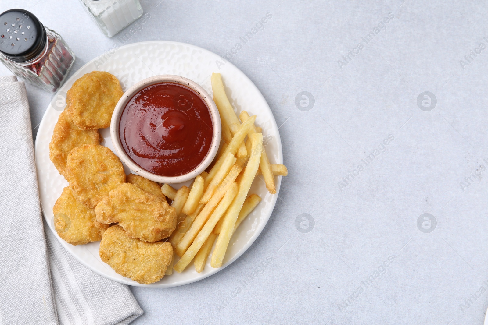 Tasty chicken nuggets and french fries with sauce on light table, flat lay. Space for text Photo of Tasty chicken nuggets and french fries with sauce on light table, flat lay. Space for text
