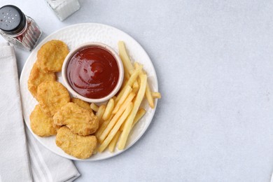 Photo of Tasty chicken nuggets and french fries with sauce on light table, flat lay. Space for text