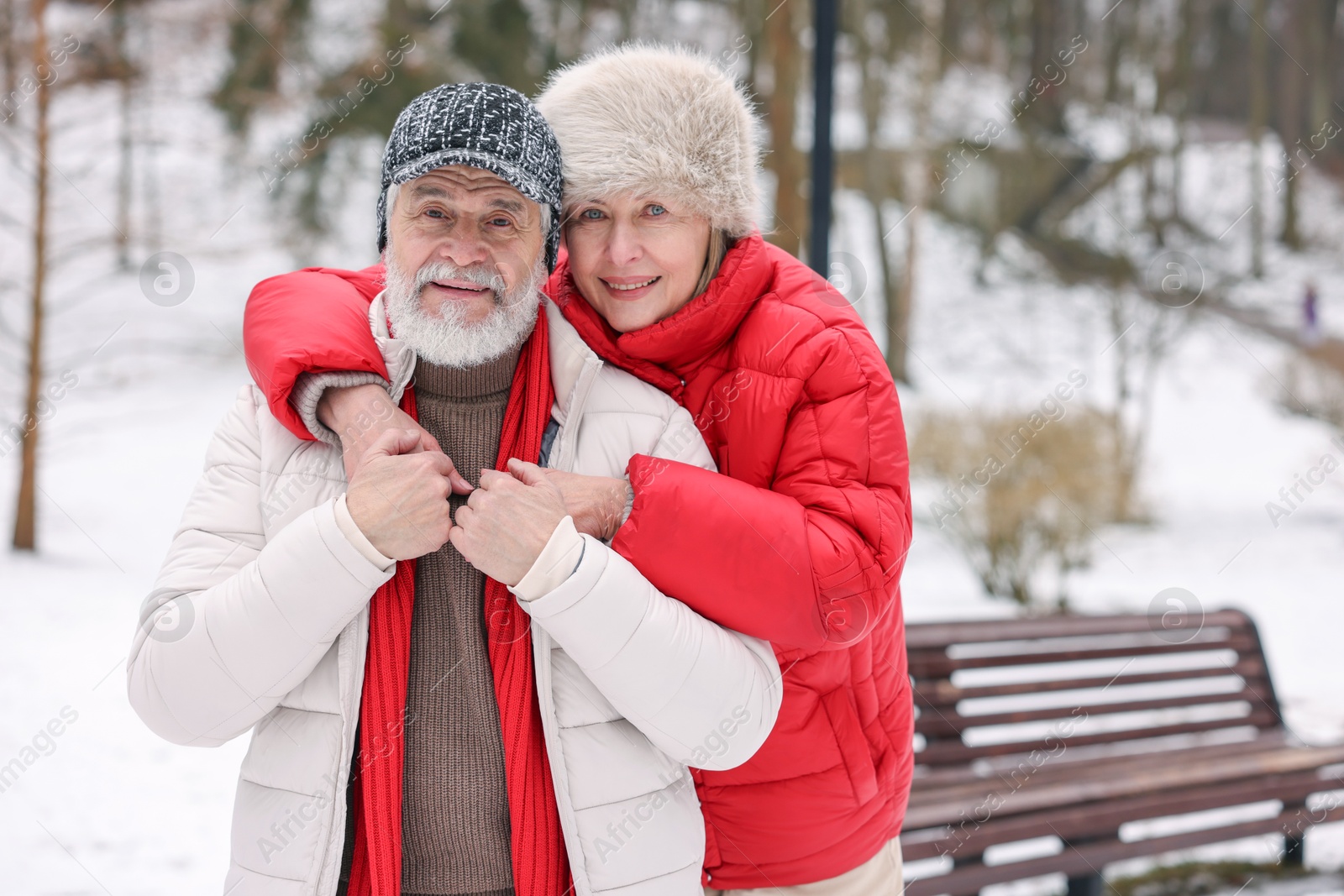 Photo of Happy senior couple at winter park. Space for text