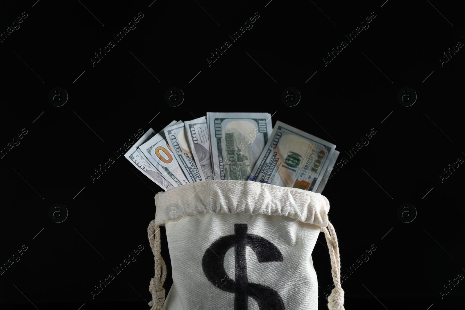 Photo of Dollar banknotes in burlap sack on black background, closeup