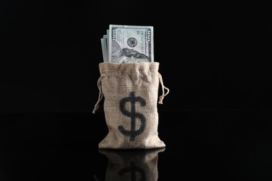 Photo of Dollar banknotes in burlap sack on dark mirror surface