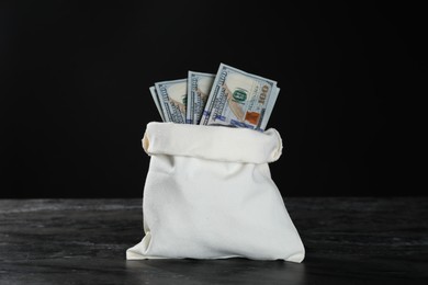 Photo of Dollar banknotes in burlap sack on grey table