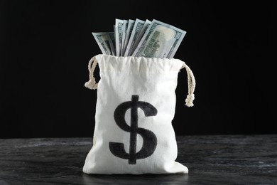 Photo of Dollar banknotes in burlap sack on grey table