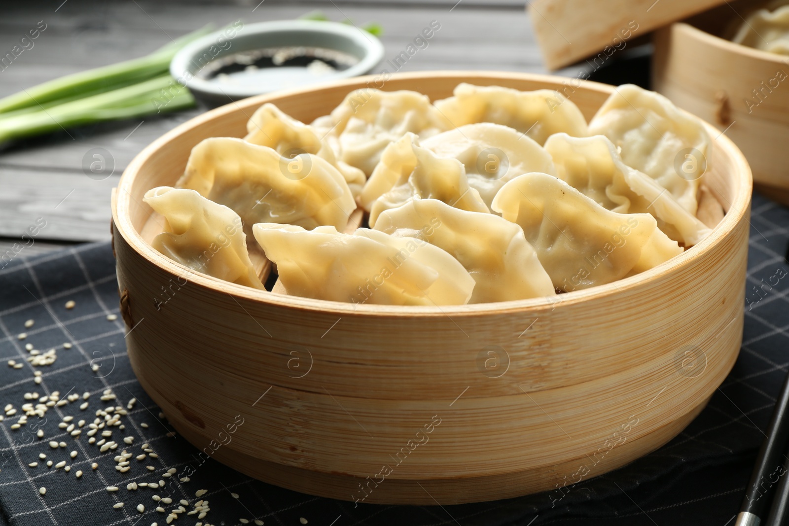 Photo of Tasty boiled gyoza (dumplings) served on black table, closeup