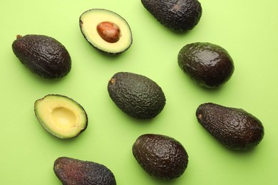 Photo of Fresh ripe avocados on light green background, flat lay