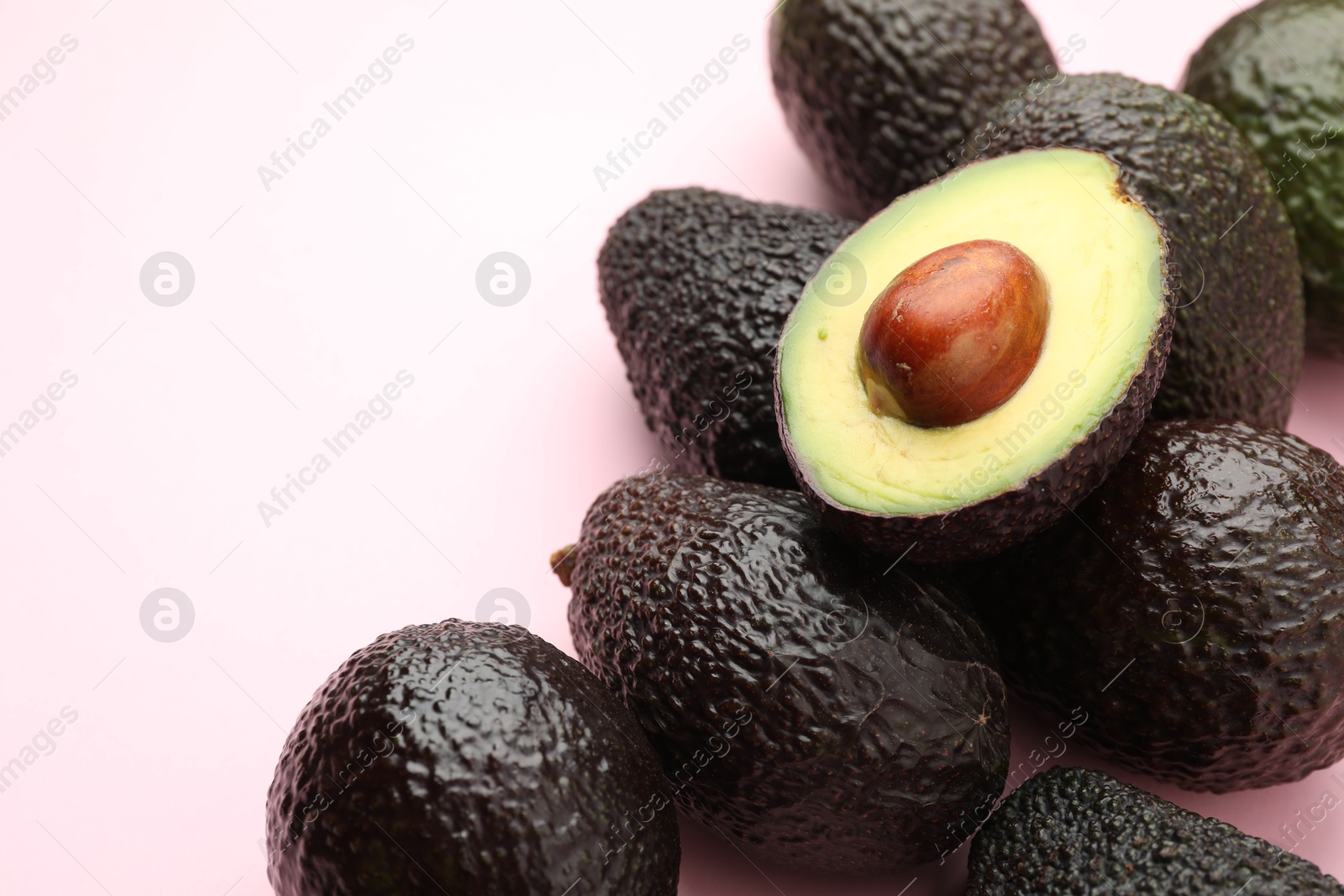 Photo of Fresh ripe avocados on pink background, closeup. Space for text