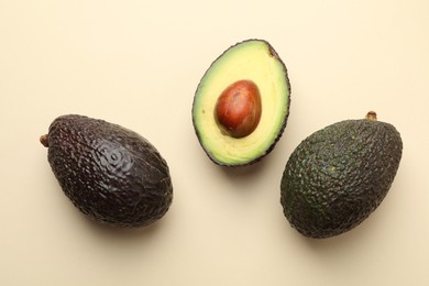 Photo of Fresh ripe avocados on beige background, flat lay