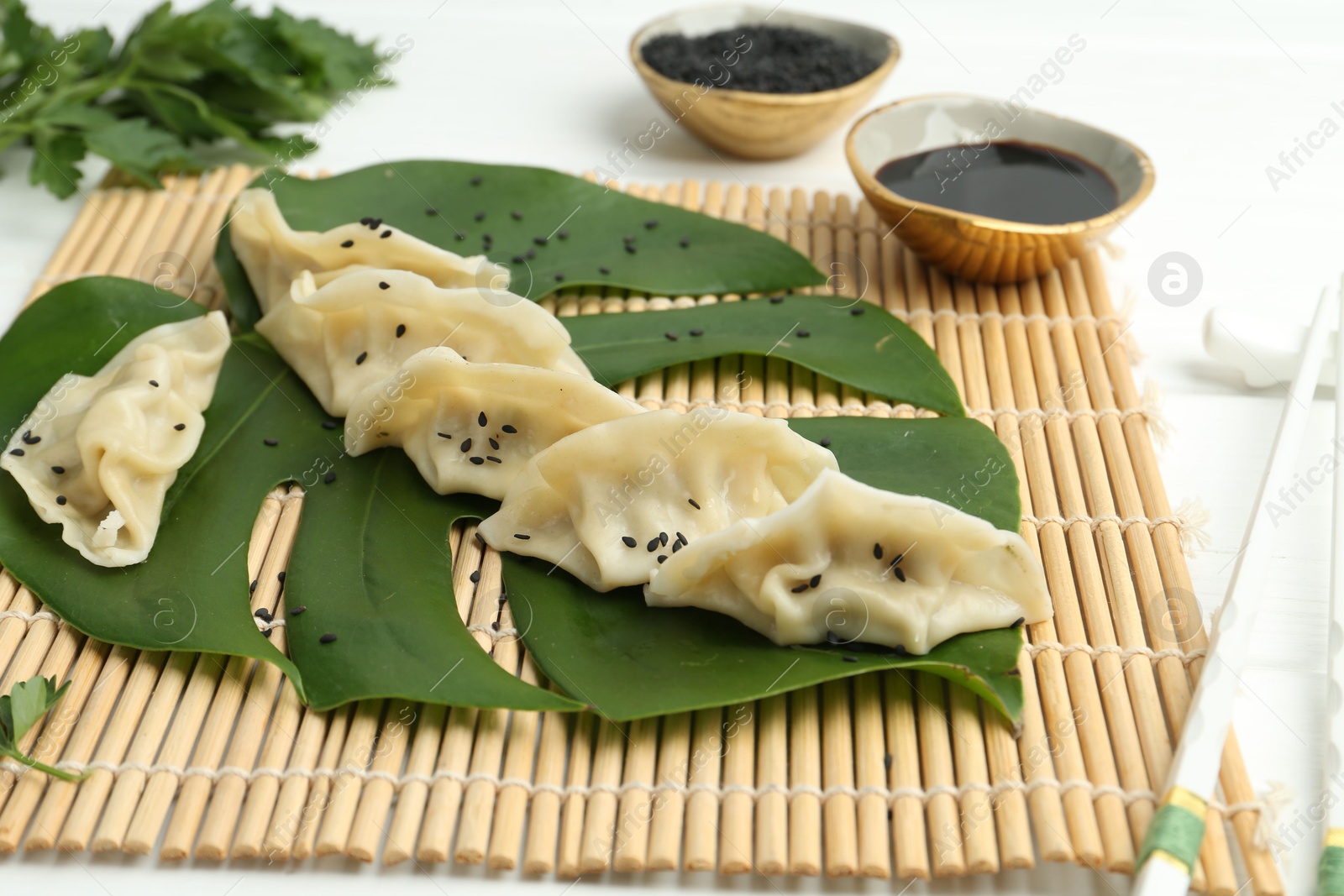 Photo of Tasty boiled gyoza (dumplings) served on white table