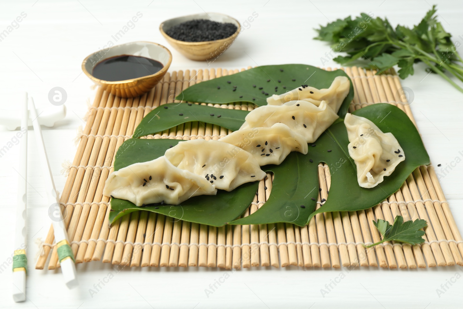 Photo of Tasty boiled gyoza (dumplings) served on white table