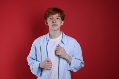 Photo of Smiling teenage boy with freckles on red background