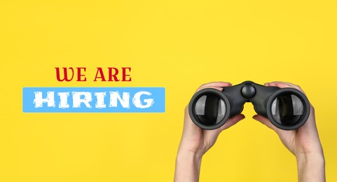 Image of We are hiring. Woman holding binoculars on yellow background, closeup. Banner design. Human resource, recruitment concept