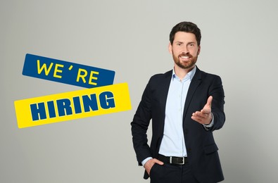 Image of We're hiring. Handsome businessman on grey background. Human resource, recruitment concept