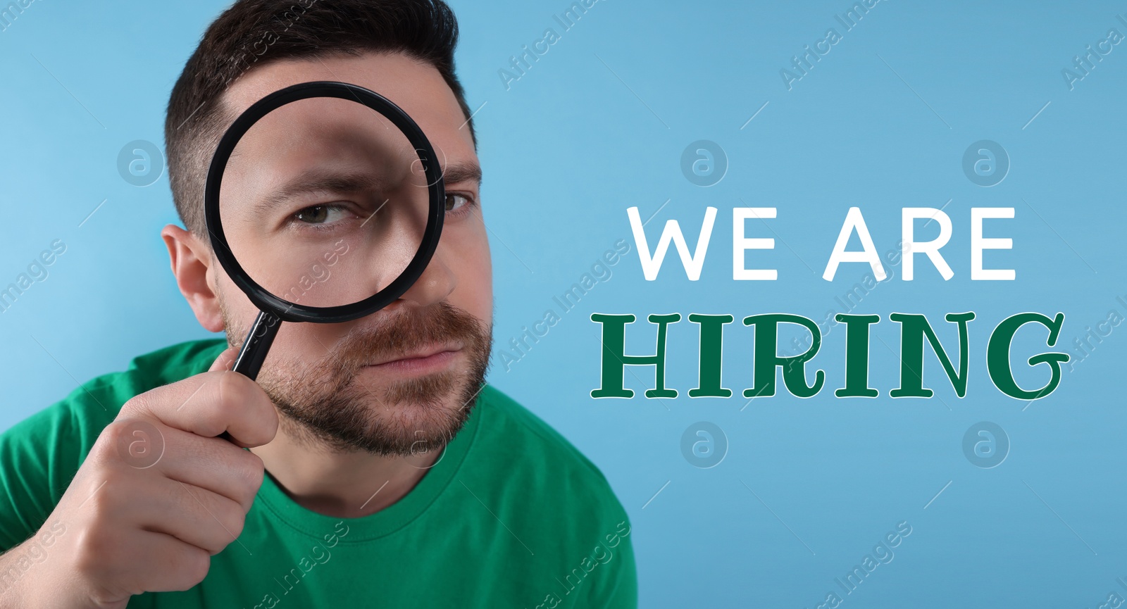 Image of We are hiring. Man looking through magnifying glass on light blue background, banner design. Human resource, recruitment concept