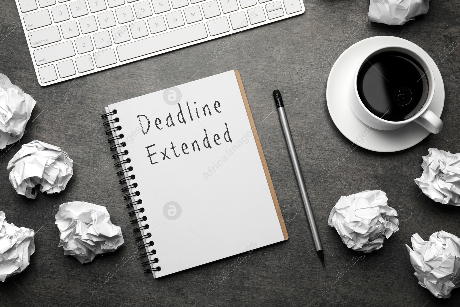 Image of Deadline Extended text in notebook, pencil, coffee, computer keyboard and crumpled paper balls on black table, flat lay