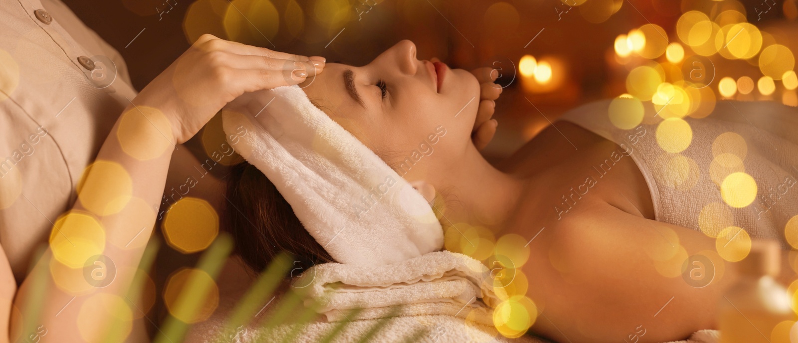 Image of Young woman receiving massage in spa salon, bokeh effect. Banner design