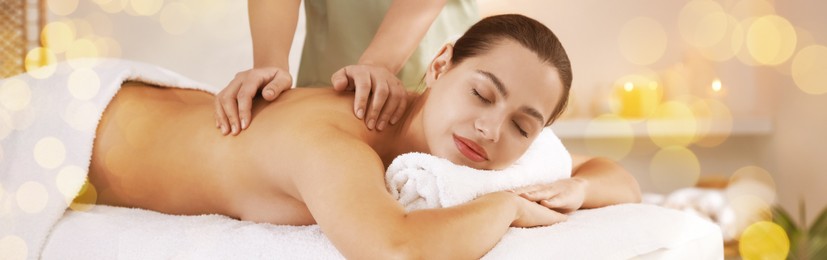 Image of Young woman receiving massage in spa salon, bokeh effect. Banner design