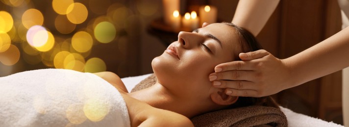 Image of Attractive woman enjoying face massage, bokeh effect. Banner design