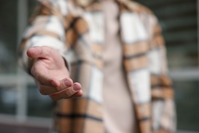 Photo of Offering help. Man reaching his hand outdoors, closeup