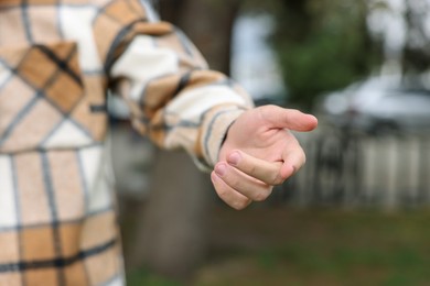 Photo of Offering help. Man reaching his hand outdoors, closeup