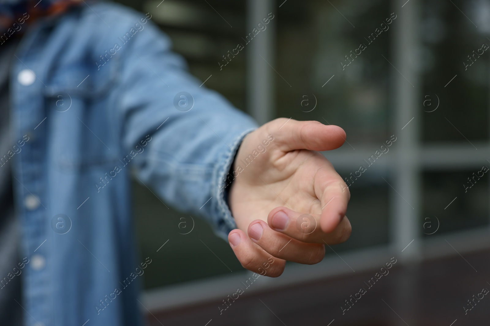 Photo of Offering help. Man reaching his hand outdoors, closeup