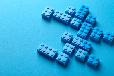 Photo of Constructor toy. Many building blocks on light blue background, above view