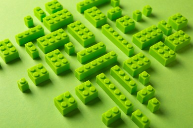 Photo of Constructor toy. Many building blocks on light green background