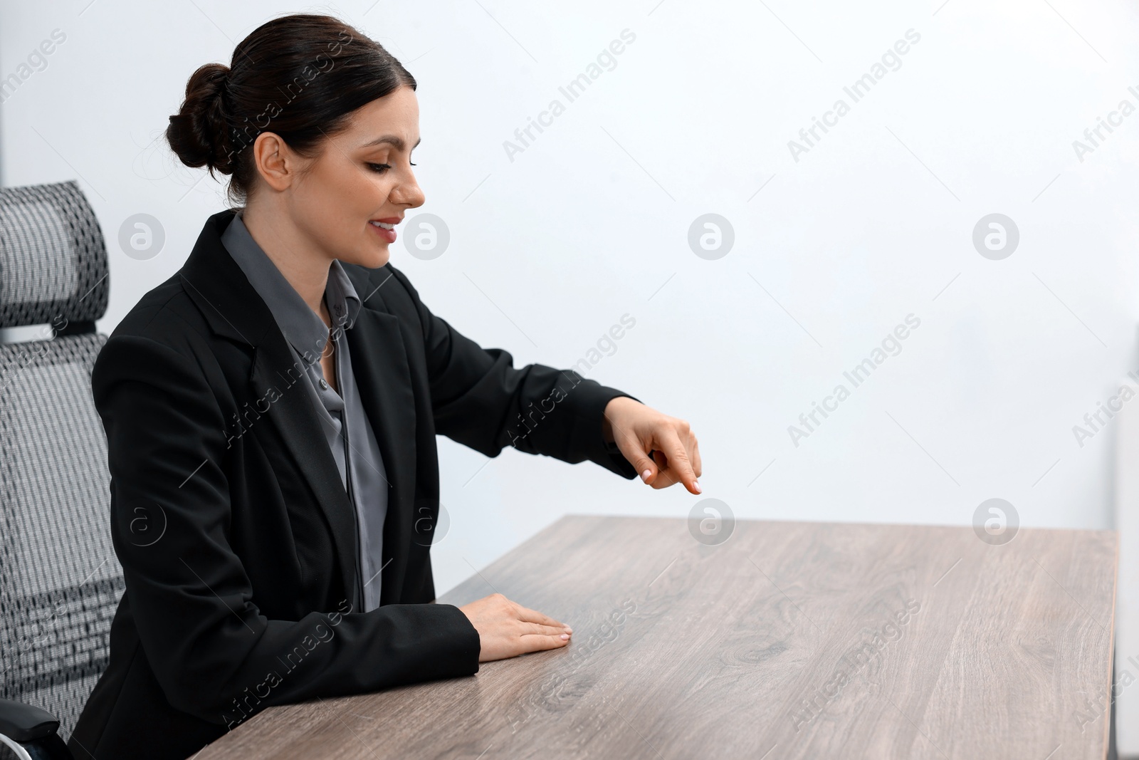 Photo of Beautiful woman pointing at something in office, space for text