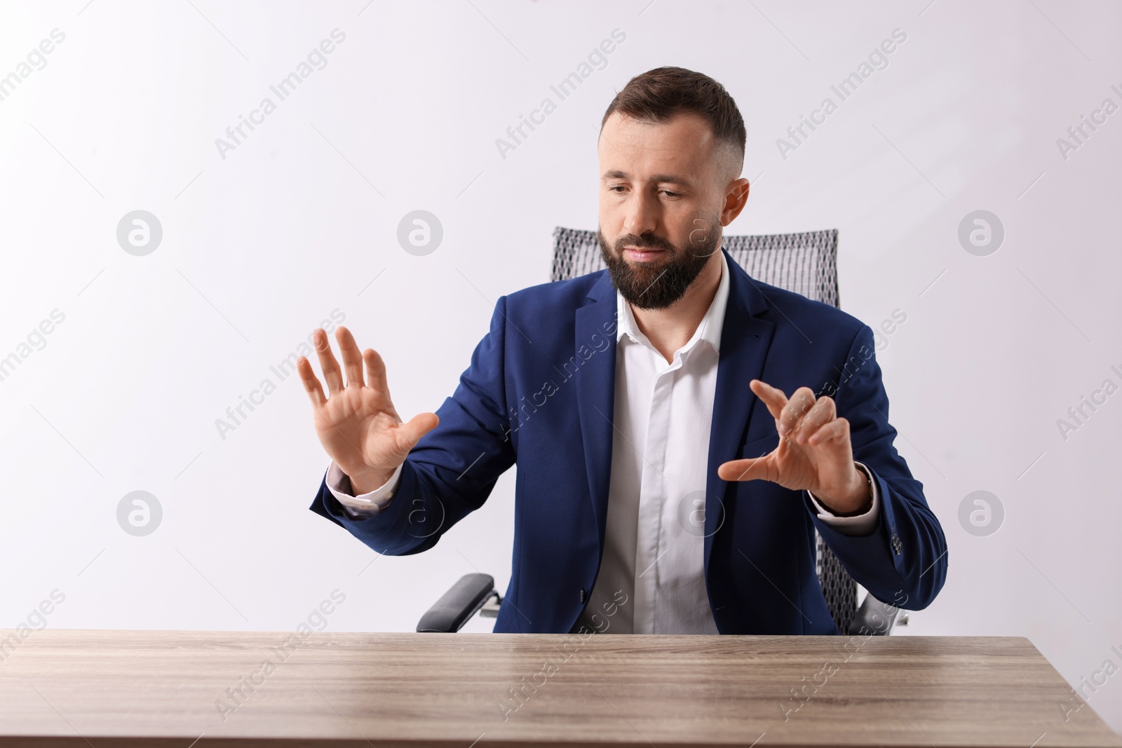 Photo of Man showing something at wooden desk in office