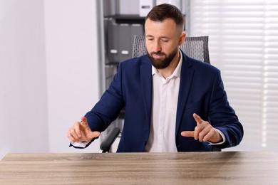 Photo of Man showing something at wooden desk in office