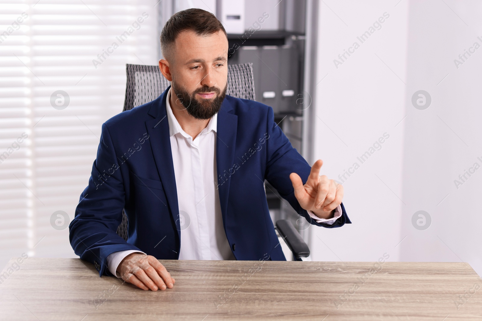 Photo of Man pointing at something at wooden desk in office, space for text