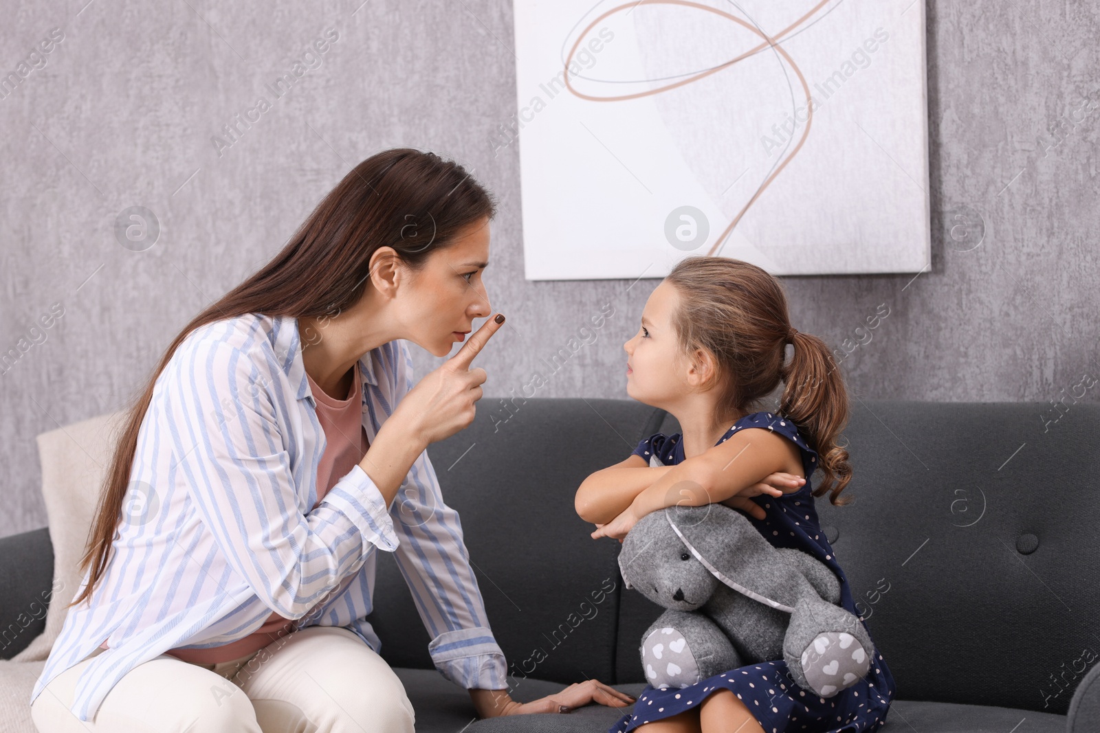 Photo of Resentful little girl and her mother arguing at home