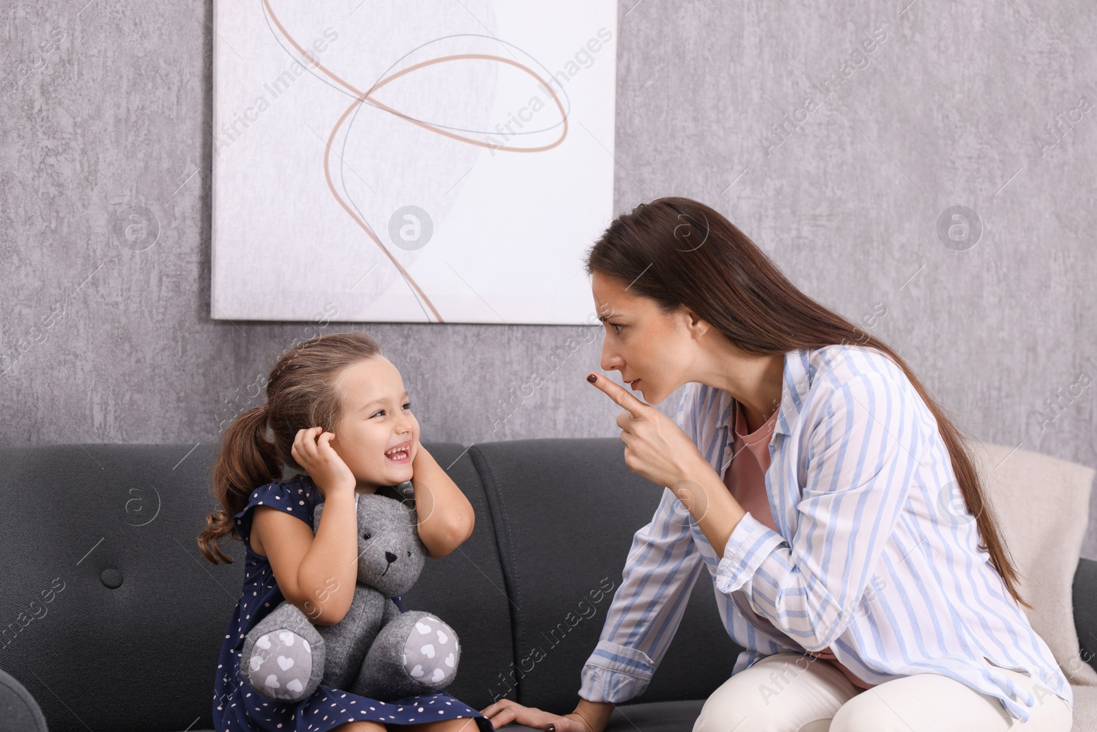 Photo of Resentful little girl and her mother arguing at home