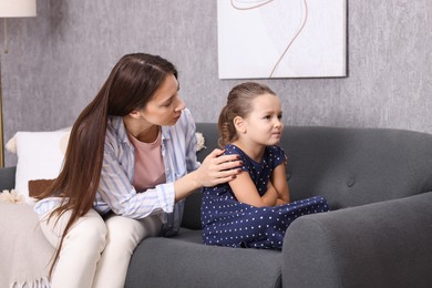 Photo of Resentful little girl and her mother at home. Family dispute