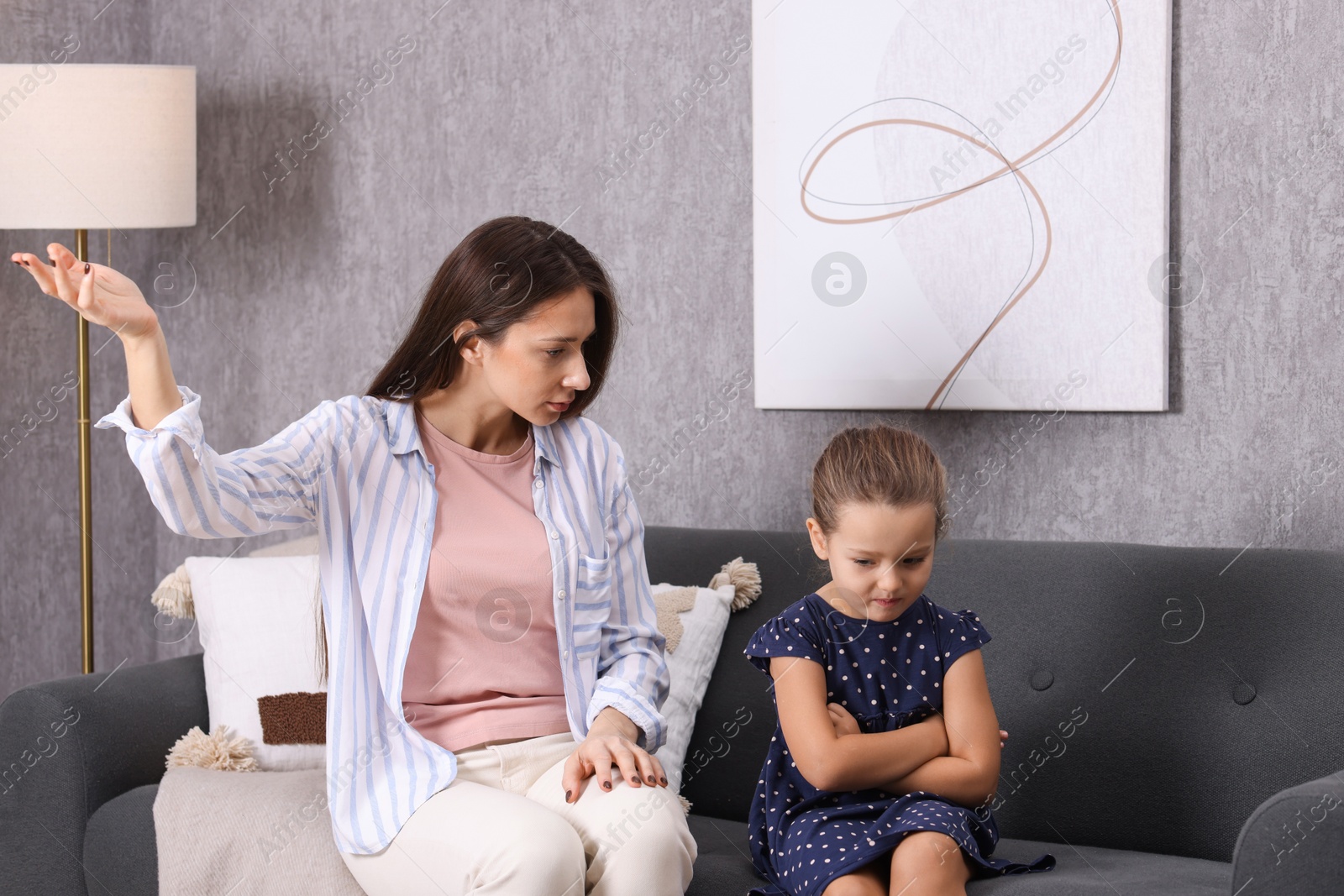 Photo of Resentful little girl and her mother arguing at home