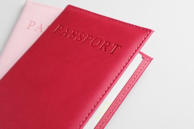 Photo of Passports in color covers on light background, closeup