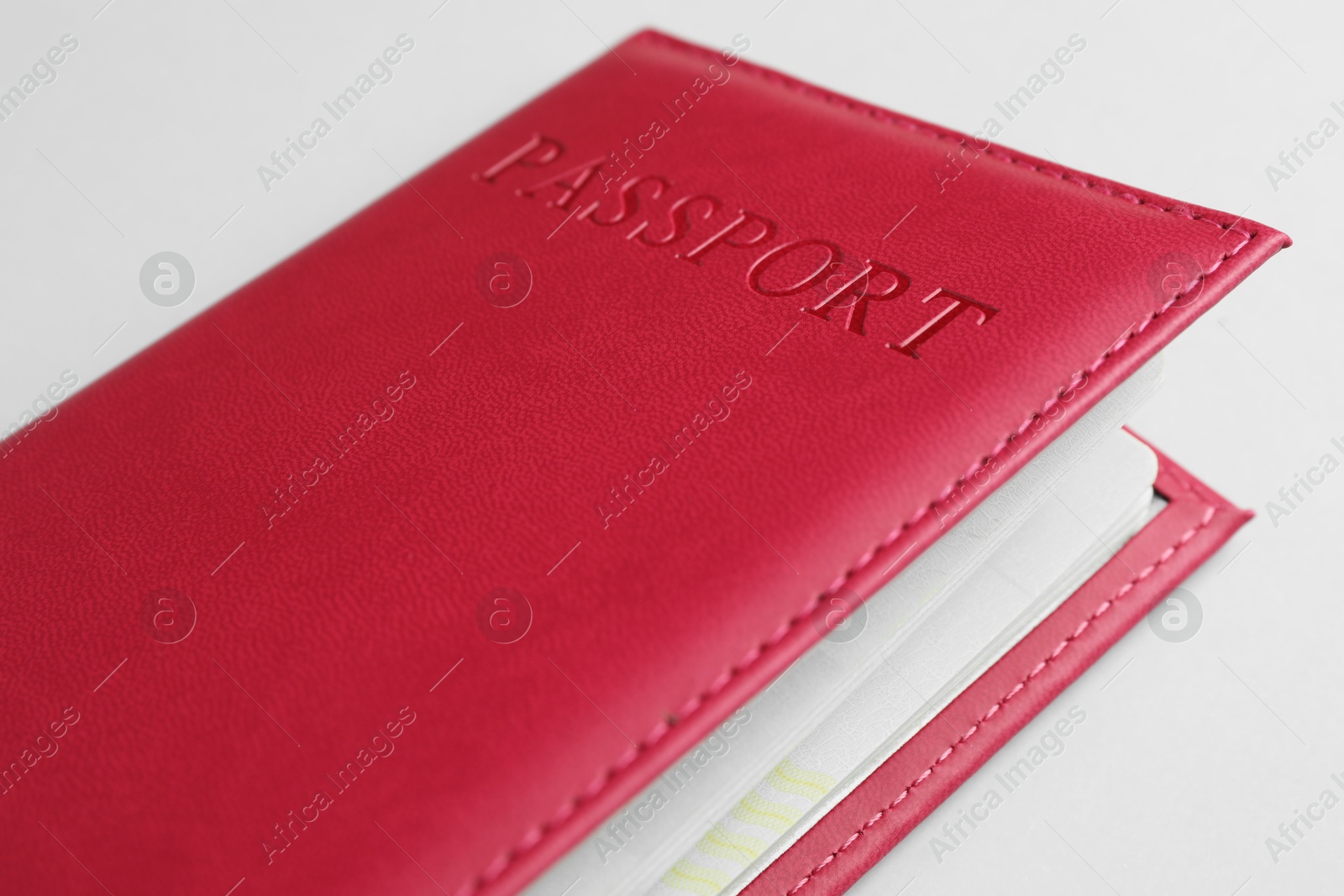 Photo of Passport in red cover on light background, closeup