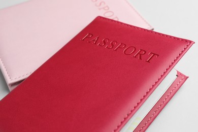 Photo of Passports in color covers on light background, closeup