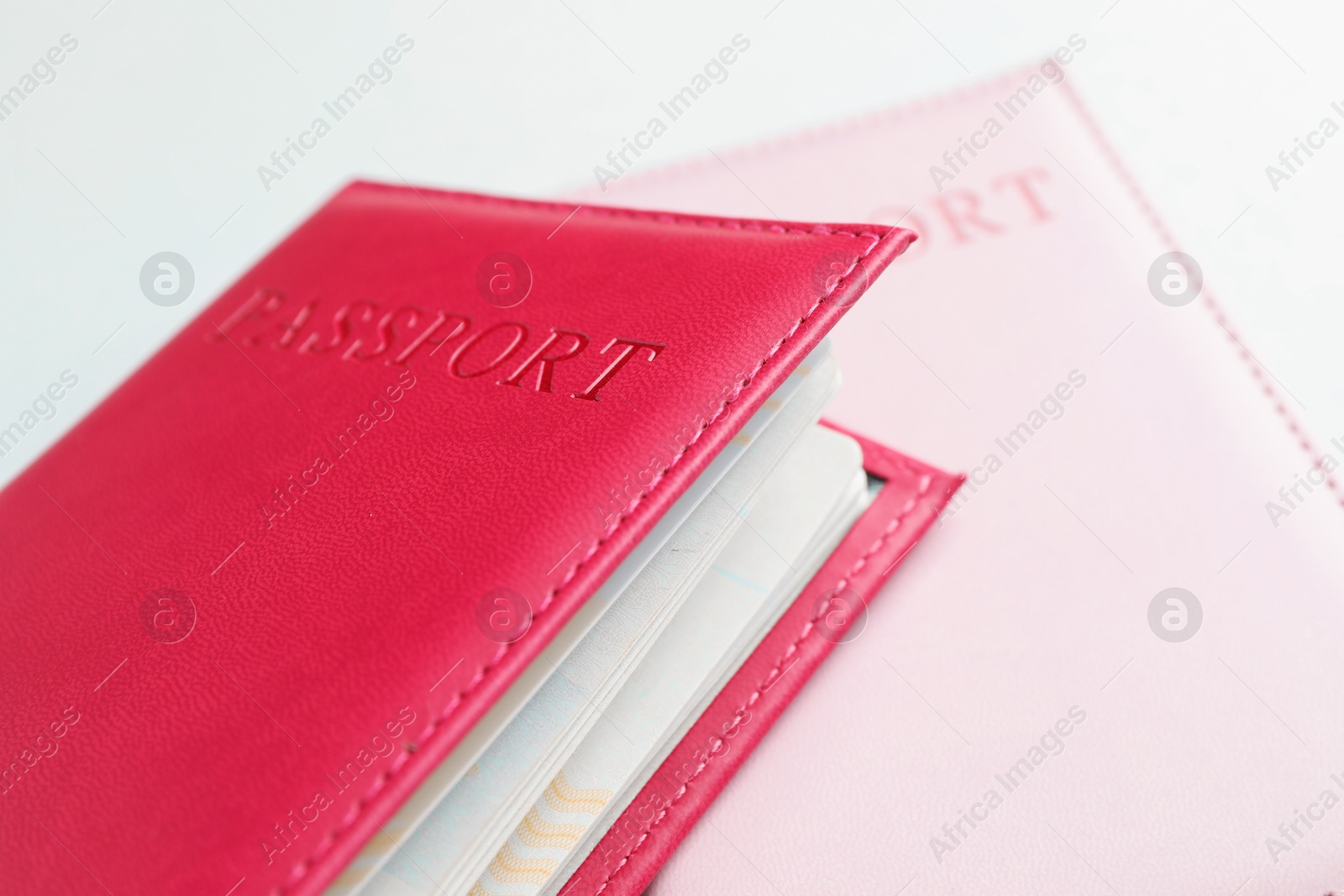 Photo of Passports in color covers on light background, closeup