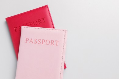 Photo of Passports in color covers on light background, top view. Space for text