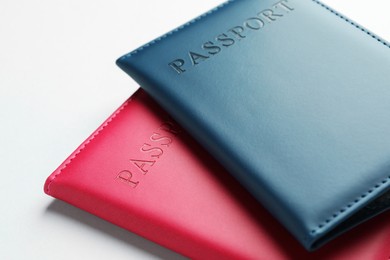 Photo of Passports in color covers on light background, closeup