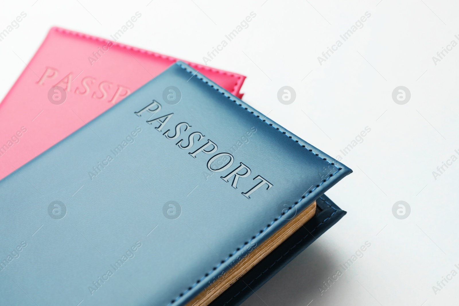 Photo of Passports in color covers on light background, closeup