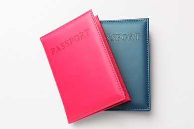 Photo of Passports in color covers on light background, top view