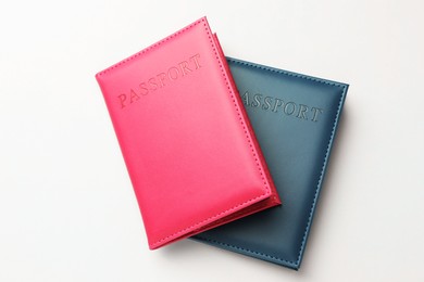 Photo of Passports in color covers on light background, top view