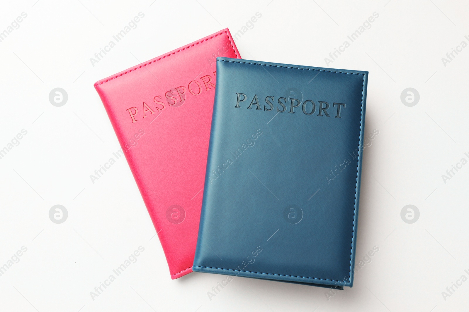 Photo of Passports in color covers on light background, top view