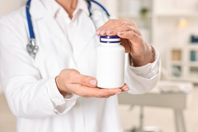 Photo of Nutritionist with bottle of weight loss pills in clinic, closeup