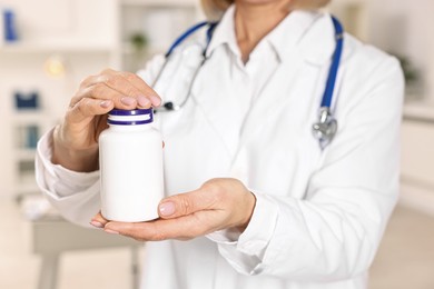 Photo of Nutritionist with bottle of weight loss pills in clinic, closeup