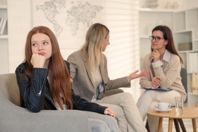 Photo of Difficult teenager. Mother and daughter having consultation with psychologist in office, selective focus