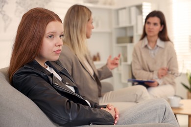 Photo of Difficult teenager. Mother and daughter having consultation with psychologist in office, selective focus